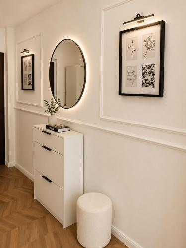 a white dressing room with a stool and a mirror at Fontana Lux Apartment in Belgrade