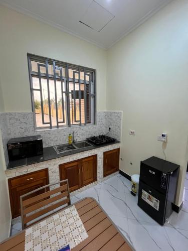 an empty kitchen with a table and a stove at Seneu Executive Residence in Mwanza
