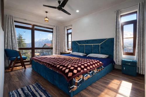 a bedroom with a blue bed and large windows at John's Homestay Srinagar - Stay Ride Hike in Srinagar