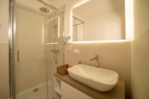 a white bathroom with a sink and a shower at Casa Delle Bollicine in Bigolino