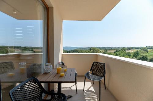 a balcony with a table and chairs and a window at Apartman Tena in Barban