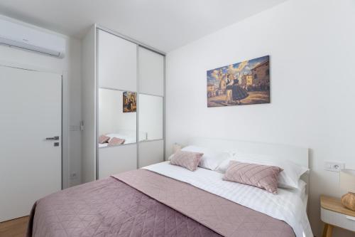 a bedroom with a bed and a painting on the wall at Apartman Tena in Barban