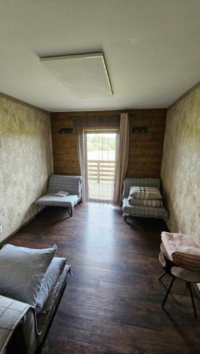 a room with three beds and a large window at ''Ābeļdārzs'' in Jelgava