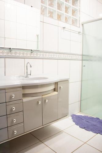 a bathroom with a sink and a shower at Chácara Eldorado in Amparo