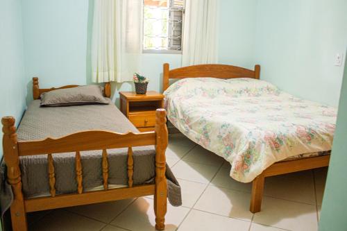 a bedroom with two twin beds and a window at Chácara Eldorado in Amparo