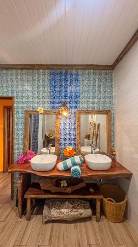 a bathroom with two sinks and two mirrors at La Digue Holiday Villa in La Digue