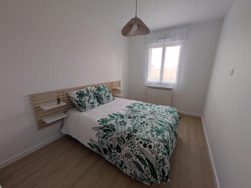 a bedroom with a bed and a window at La Maison Menhiria in Dol-de-Bretagne