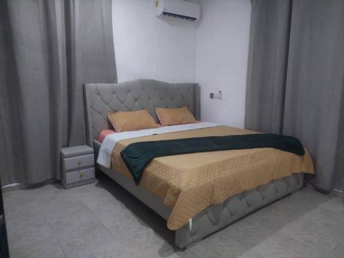 a bedroom with a bed with a metal headboard at Monroe Luxury Apartments in Kumasi