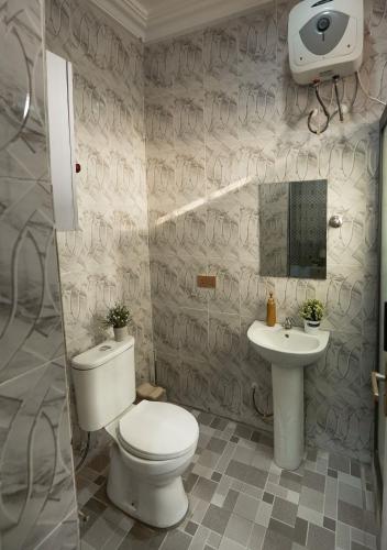 a bathroom with a toilet and a sink at Monroe Luxury Apartments in Nsima