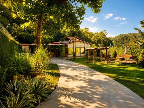 a walkway in a yard with a house at Casa Moderna e Espaçosa com Piscina e Lareira na Serra da Cantareira in Mairiporã