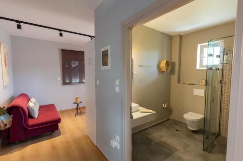 a bathroom with a red chair and a toilet at Marion Apartments in Kourouta