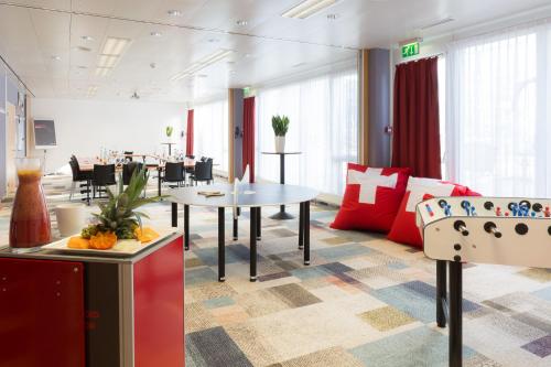 a living room with a couch and a table at ibis Zürich Messe Airport in Zürich