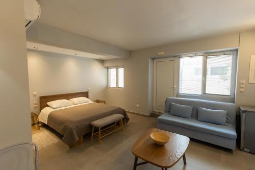 a bedroom with a bed and a blue couch at Marion Apartments in Kourouta