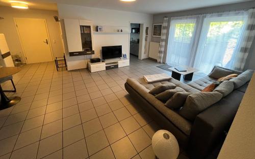 a living room with a couch and a tv at Apartment Akazie in Weinsheim
