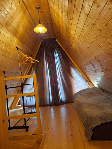 a bedroom with a bed in a wooden ceiling at WILD NEST Cottage 