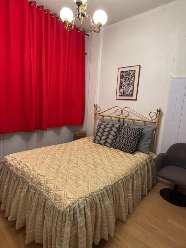 a bedroom with a bed with a red curtain at Apartamento para duas pessoas com cama de casal in Teresópolis