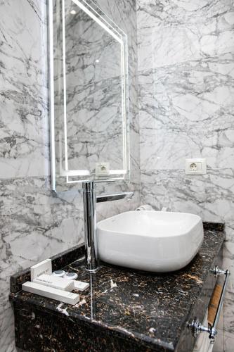 a bathroom with a white sink and a mirror at Delmar Boutique Buzovna in Mekhrably