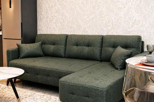 a green couch sitting in a living room at Delmar Boutique Buzovna in Mekhrably