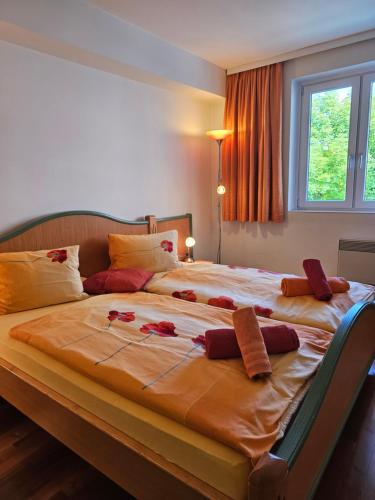 a large bed with flowers on it in a bedroom at Pension Schachner in Schladming