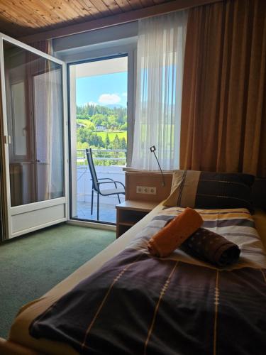 a bedroom with a bed with a view of a balcony at Pension Schachner in Schladming