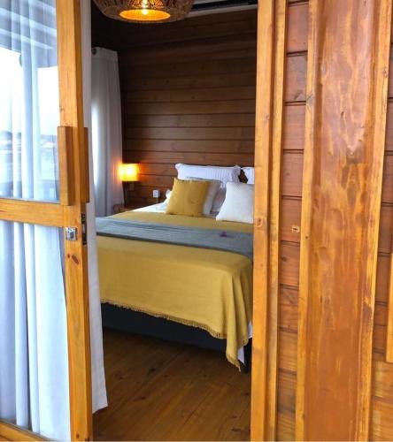a bedroom with a bed with yellow sheets and pillows at Vila do Pescador in Camocim