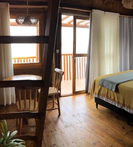 a bedroom with a bed and a wooden floor at Vila do Pescador in Camocim