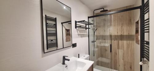 a white bathroom with a sink and a shower at Apartamentos Saila in Castejón de Sos