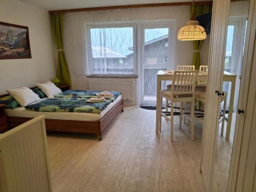a bedroom with a bed and a table and a window at Ferienwohnung 6 Bergblick in Sankt Gilgen
