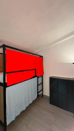 a room with a bed with a red blanket on it at Can Cocollona in Girona