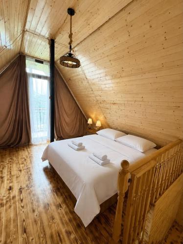 a bedroom with a large bed in a wooden room at Eco house luma in K'eda