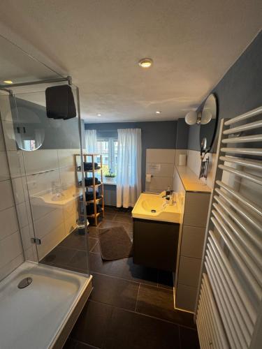 a bathroom with a tub and a sink and a shower at Ferienwohnung Gänsemarkt in Born