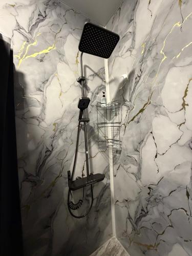a shower in a bathroom with a stone wall at M&M Hotel in Pʼarakʼar