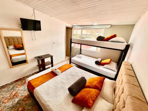 a bedroom with two bunk beds and a television at Hotel Flamante Bulevar in Bogotá