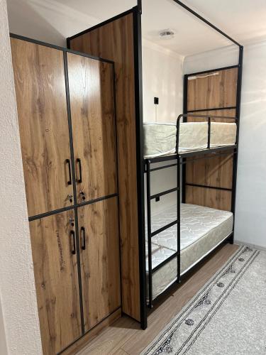 a room with two bunk beds and a closet at Teskey Hostel Karakol in Karakol