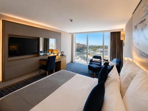 a hotel room with a large bed and a television at شير فل in Unayzah