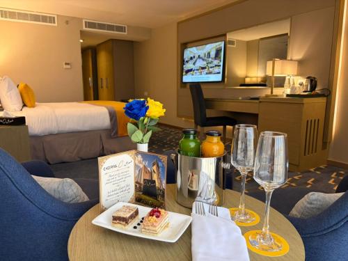 a hotel room with a table with food and wine glasses at شير فل in Unayzah