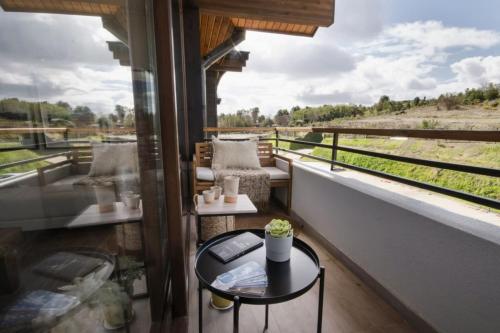 a balcony with a table and a view of a field at Private Terrace with Wellness Studio & Fireplace in Puerto Varas