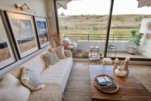 a living room with a white couch and a large window at Private Terrace with Wellness Studio & Fireplace in Puerto Varas