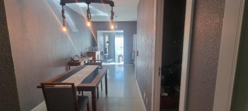 a dining room with tables and chairs and a hallway at Cantinho das Orquídeas! in Pelotas