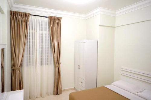 a bedroom with a bed and a window with curtains at Cameron View Apartment @ Crown Imperial Court Brinchang in Cameron Highlands
