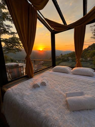 a bedroom with a bed with the sunset in the background at Merisi - Sunset Chalet in Merisi