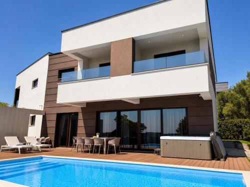 a house with a swimming pool in front of it at Villa Estate in Novalja
