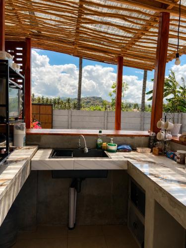 a kitchen with a sink and a large window at Wavez Lombok Hostel in Selong Belanak