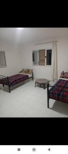 a room with two beds and a table in it at Transit in Nouakchott