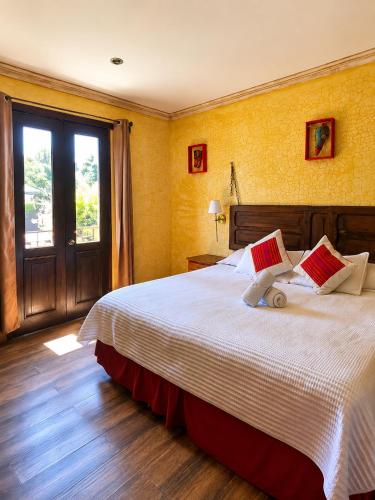 a bedroom with a bed with a teddy bear on it at Casa Mia Hotel in Antigua Guatemala