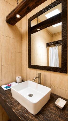 a bathroom with a white sink and a mirror at Casa Mia Hotel in Antigua Guatemala