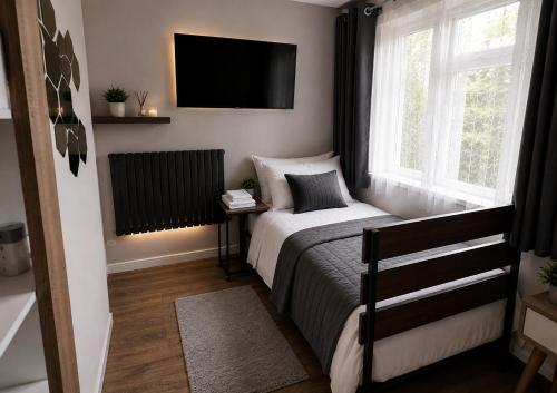a bedroom with a bed and a television on the wall at Number 25 in Horley