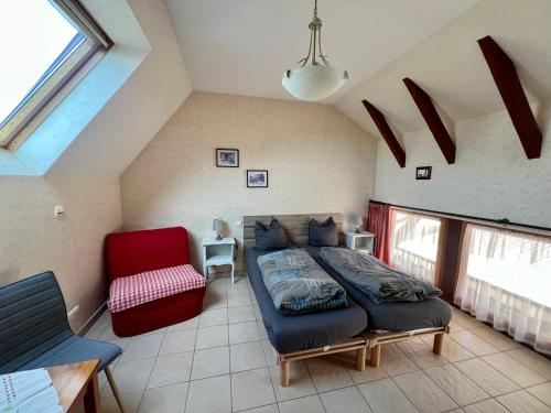 a bedroom with a bed and a red chair at Mélodies d'Alsace in Lipsheim