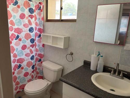 a bathroom with a toilet and a sink at Front Beach Beautiful house with pool & AC in Pochomil