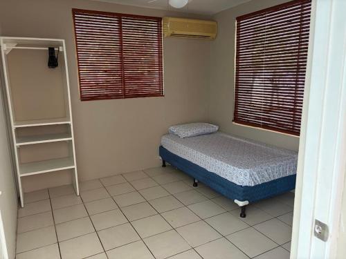 a small bedroom with a bed and a book shelf at Front Beach Beautiful house with pool & AC in Pochomil